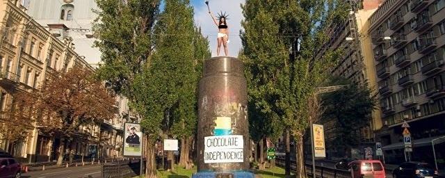 В Киеве активистка Femen бросала конфеты Roshen с памятника Ленину