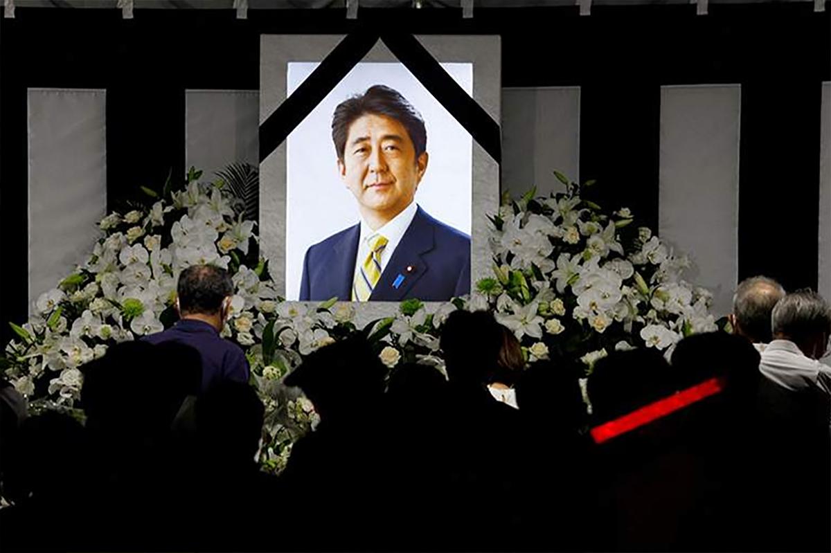 Люди несут цветы к перекрестку у станции Ямато-Сайдайдзи в Наре