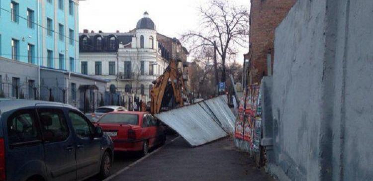 В центре Ростова забор упал на припаркованные авто и спецтехнику